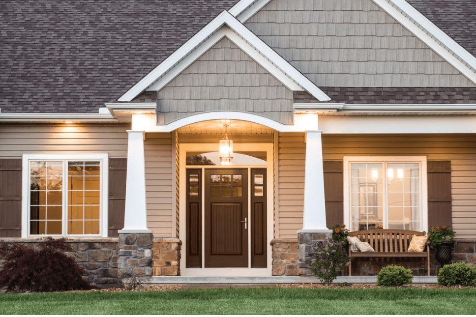 Front exterior of a two-story home with a brown entry door with sidelites.