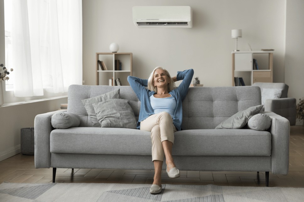 Person enjoying air from their home cooling system on their couch.