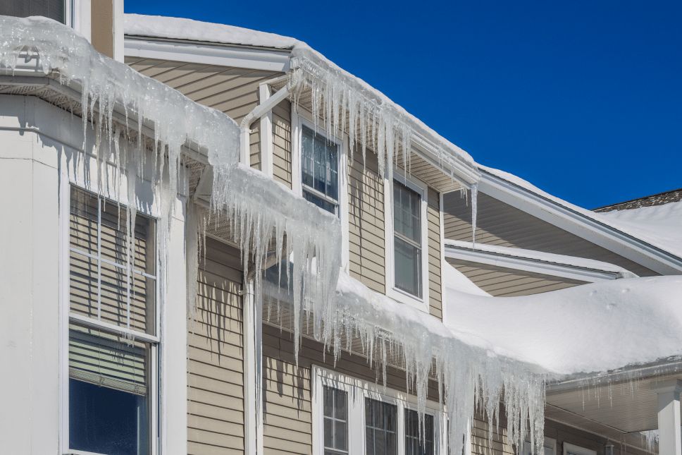 A home with beige siding and many large icicles hanging from the gutters.