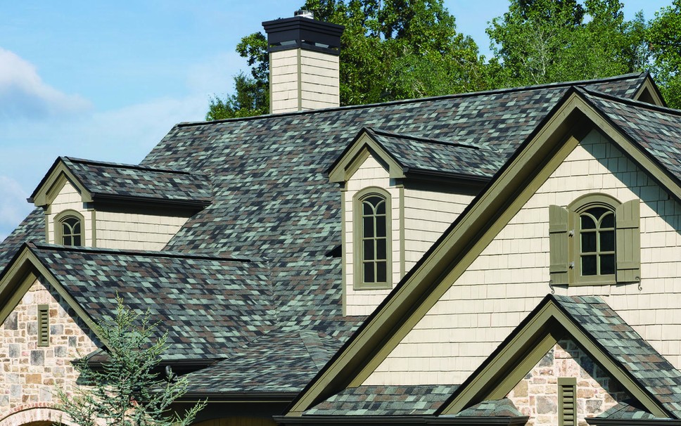 Roof of a large home with a mixture of asphalt roof shingles that is in very good condition.